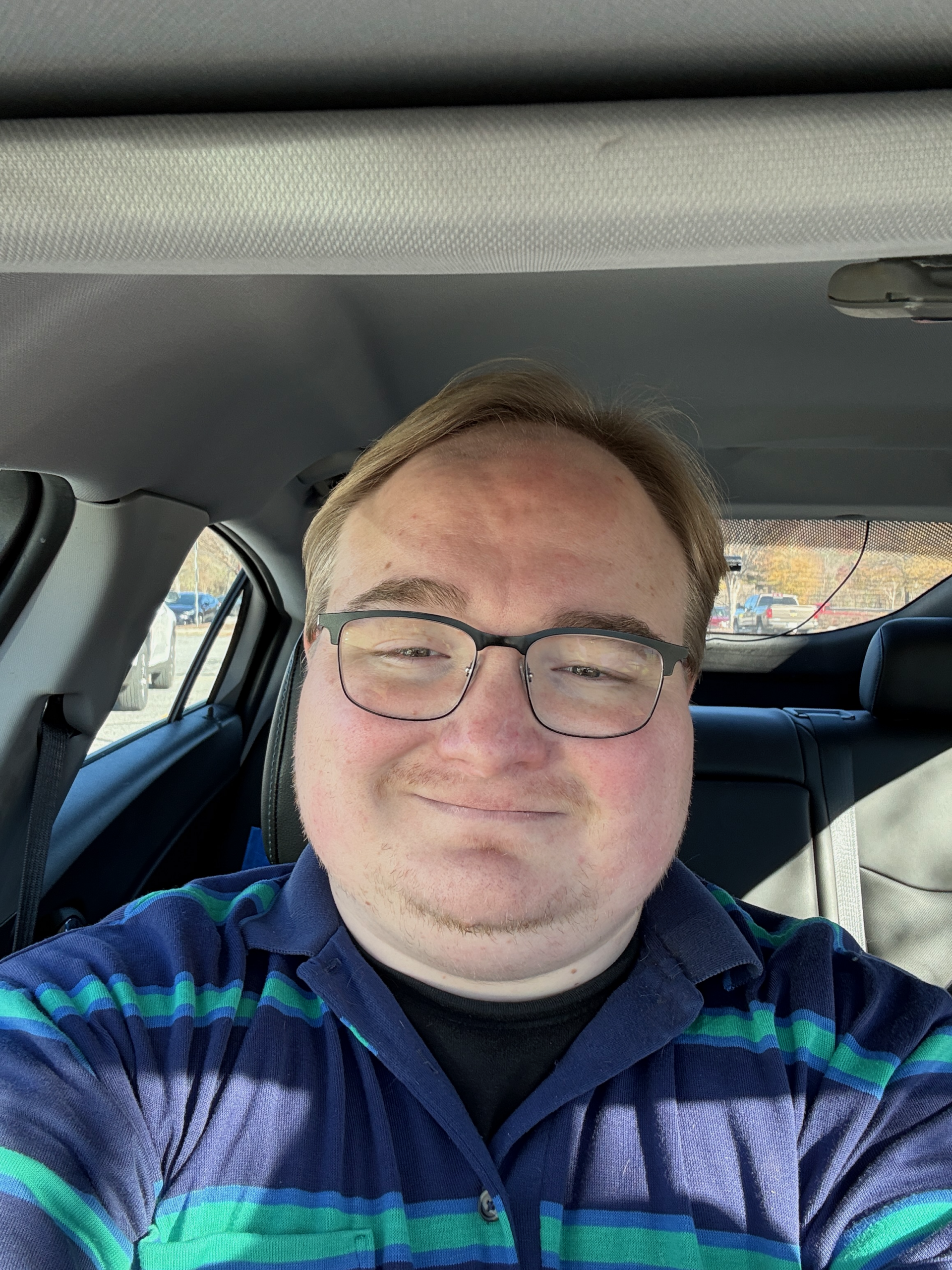 IMG_4988 Owner and operator, Ben Sanders wearing a dark blue and green striped collered shirt.